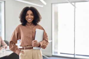 Happy young African business woman standing in office. Portrait. Copy space.